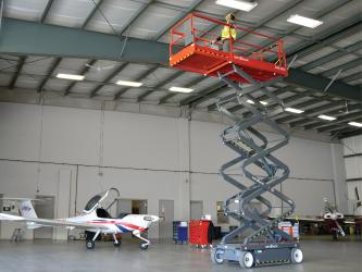 plataforma de tijeras skyjack en un hangar de aeronaves